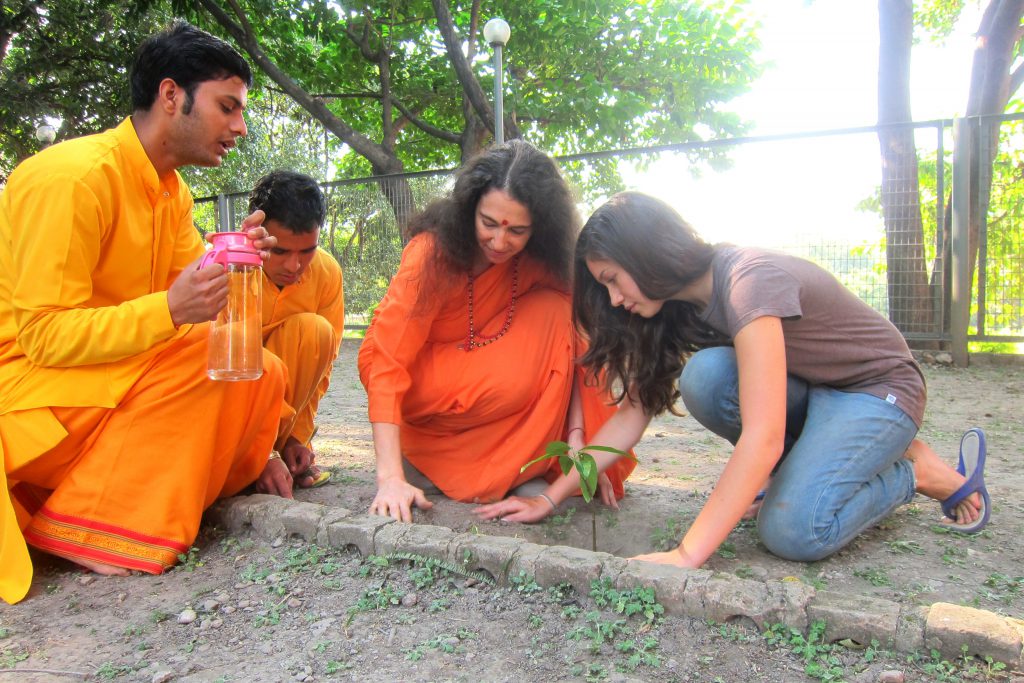Rachel with friends planting a tree.