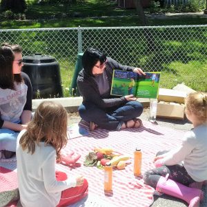 Young lady reading to two young girls
