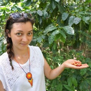 Jessica holding coffee tree fruit at a farm in Cuba