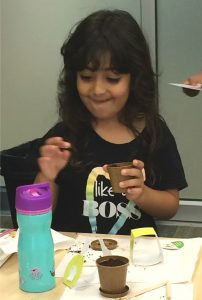 Young girl excited to see bush beans seeds for her planting kit at Coquitlam Library's Plant a Seed READ!