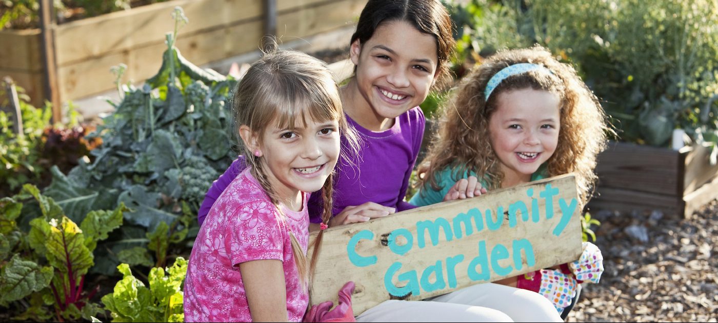 Girls holding community garden sign
