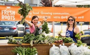 Jessica Hill holding kale at Fresh Roots